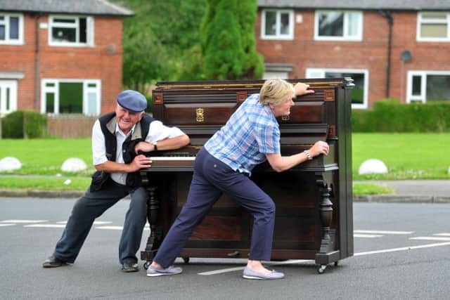 Graham Tempest and his sister Margaret Audsley push an upright piano through the streets of Gipton, as they did in the 19050s. Picture by Tony Johnson