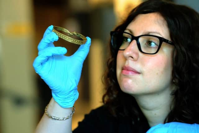 Natalie McCaul Curator of Archaeology at the Yorkshire Museum iwith a gold armlet, the only piece of gold  in  the The Vale of York Hoard