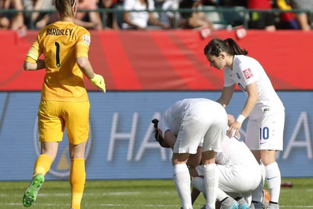 England's Laura Bassett, second from right, is consoled by teammates after the side went out in the semifinal of the FIFA Women's World Cup soccer tournament.