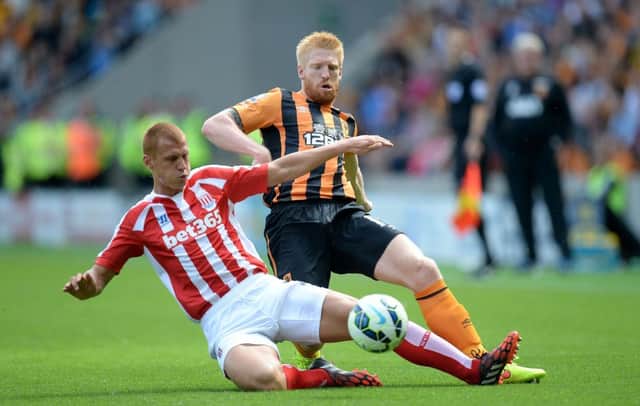 Hull City's Paul McShane battles for the ball with Stoke City's Steve Sidwell, during the Barclays Premier League match at the KC Stadium, Hull. PRESS ASSOCIATION Photo. Picture date: Sunday August 24, 2014. See PA story SOCCER Hull. Photo credit should read: Martin Rickett/PA Wire. RESTRICTIONS: Editorial use only. Maximum 45 images during a match. No video emulation or promotion as 'live'. No use in games, competitions, merchandise, betting or single club/player services. No use with unofficial audio, video, data, fixtures or club/league logos.