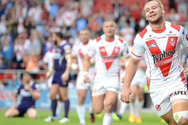 St Helens' Adam Quinlan celebrates his try against Huddersfield Giants.