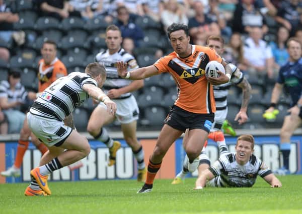 Castleford Tigers' Denny Solomona prepares to hold off Hull FC's Jordan Rankin. Picture: Anna Gowthorpe.
