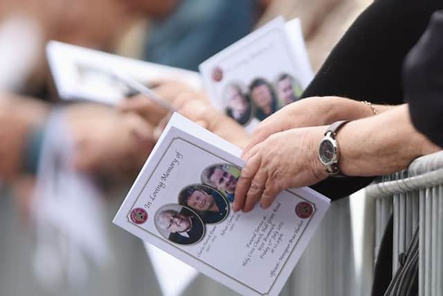 Mourners hold the order of service for three members of the same family from Walsall in the West Midlands, killed in the Sousse terror attack in Tunisia, Joel Richards, 19, his uncle, 49-year-old Adrian Evans, and his grandfather, Charles Patrick Evans, 78
