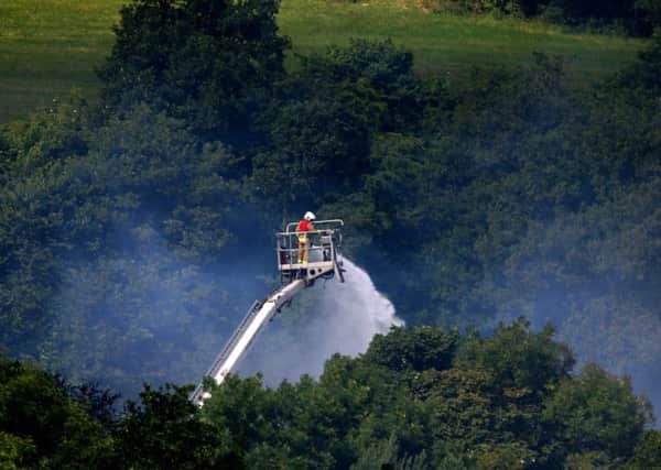 A fireman dampens down the scene of an explosion and fire where four people are still missing at Wood Flour Mills in Bosley, Cheshire. Picture: Peter Byrne/PA Wire