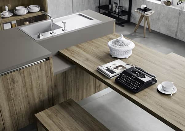 Kitchen from Michael Wrighjt  with clever island that features sink, work space and a dining table and benches