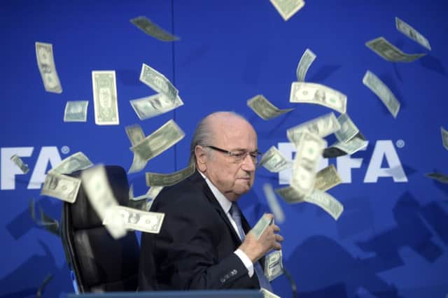 FIFA president Sepp  Blatter was photographed  while banknotes thrown by British comedian Simon Brodkin hurtled through the air during a press conference in Zurich