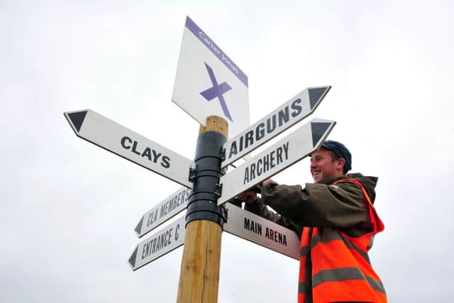 Workers put up signs around the site for the CLA Game Fair at Harewood House