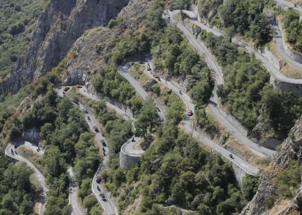 Riders, team cars and press motorcycles climb the hairpins of Montvernier yesterday (Picture: Laurent Cipriani/AP).