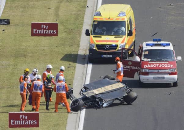 SHAKEN: Force India driver Sergio Perez of Mexico, in green helmet, stands next to his overturned car