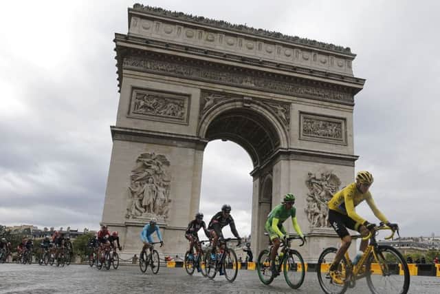 Britain's Chris Froome wearing the overall leader's yellow jersey cycles past the Arc de Triomphe earlier today. Picture: AP.