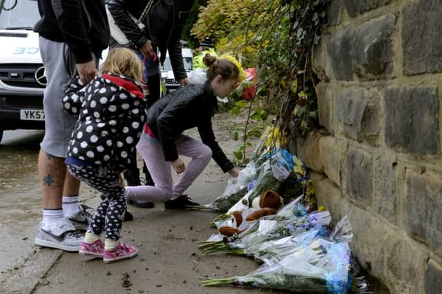 Families leave floral tributes at the building site in Bank End Road, Worsbrough, Barnsley,  where the body of 7 year old Conley Thompson was found