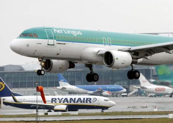 Aer Lingus Airbus A320 landing as a Ryanair plane taxi's at Dublin Airport. PRESS ASSOCIATION Photo.