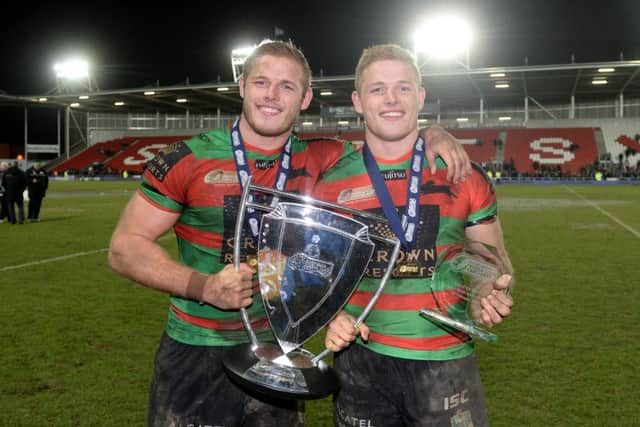 EYE ON THE PRIZE: South Sydney Rabbitohs' Tom Burgess (left) and George Burgess pose with the World Club Series trophy after winning at St Helens in February this year.
