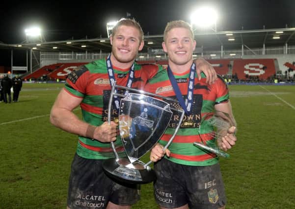 EYE ON THE PRIZE: South Sydney Rabbitohs' Tom Burgess (left) and George Burgess pose with the World Club Series trophy after winning at St Helens in February this year.