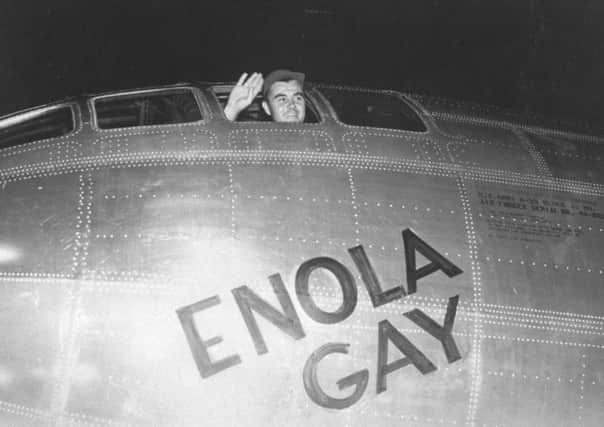 Col. Paul Tibbetts waving from the pilot's seat of Enola Gay moments before takeoff to drop the first atomic bomb on Hiroshima, Japan.  (Photo by Richard Cannon/Us Air Force/The LIFE Picture Collection/Getty Images)