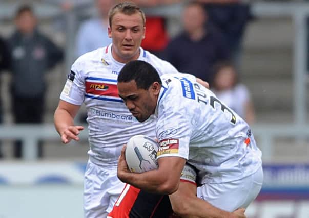 Wildcats' Bill Tupou is brought to ground by the Salford defence