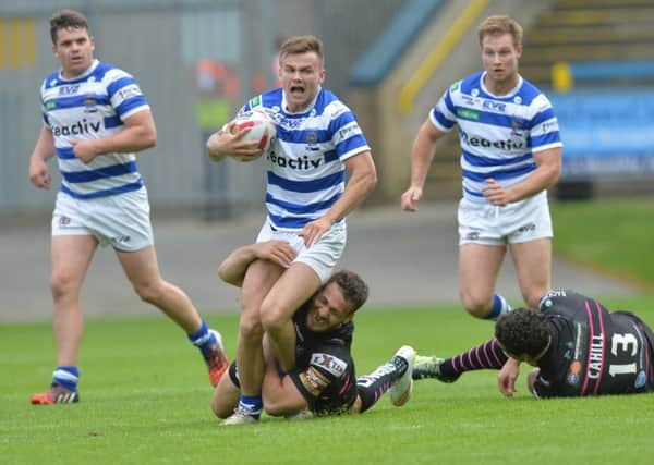 Halifax's Ben Johnston is tackled by Widnes Vikings' Lloyd White. Picture: Anna Gowthorpe