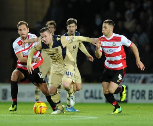 Doncaster Rovers v Leeds United.  SkyBet Champioship.  Ross McCoramck breaks clear of Martin Woods and Dean Furman.
14 December 2013.
Picture Bruce Rollinson
