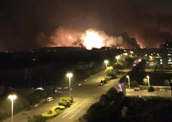 In this photo released by Xinhua News Agency smoke and fire erupt into the night sky after an explosion in the Binhai New Area in north China's Tianjin Municipality on Thursday Aug. 13, 2015. Chinese state media reported huge explosions at the Tianjin port late Wednesday with large numbers of people reported injured. (Yue Yuewei/Xinhua via AP) CHINA OUT - NO SALES