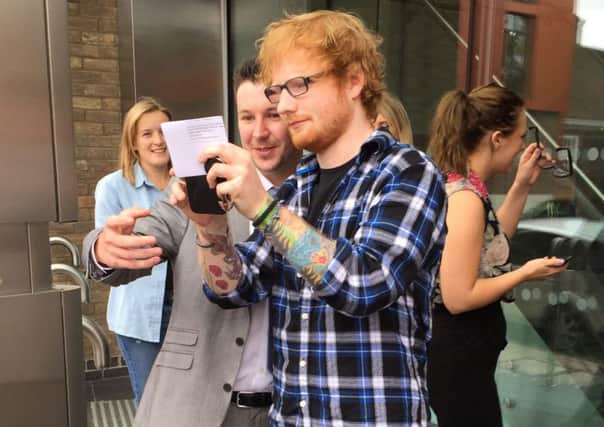 These pictures show Ed Sheeran walking out of a driving theory test centre with a massive smile on his face as he clutches his test results. (Picture: Mark Rothwell / SWNS)