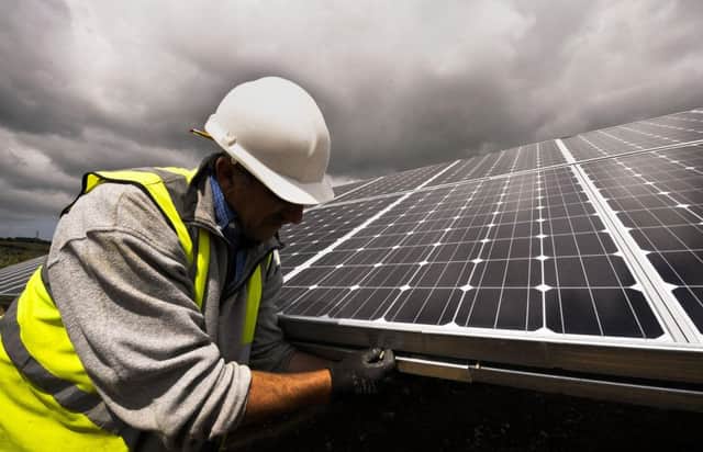 A construction engineer checking solar panels at a solar farm  Photo: Ben Birchall/PA Wire