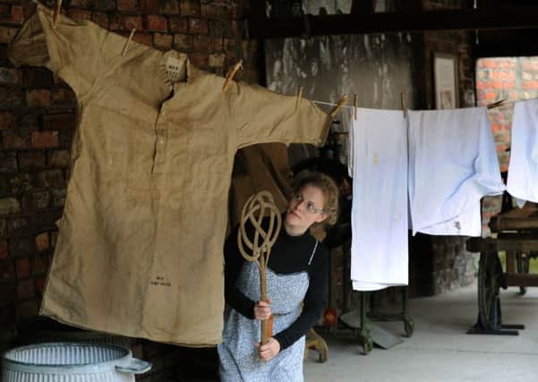 140815 Amelia Bell 19 from West Tanfield a volunteer at the Ripon Workshouse musem  cleaning the huge tramps nightgown  from the 1930's that came from the Knaresborough workhouse  and was found by a Ripon couple when Spring cleaning (Gl1006/89b)