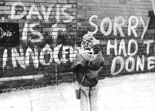 A young cricket fan reads protesters' graffiti near the Headingley gates in 1975.