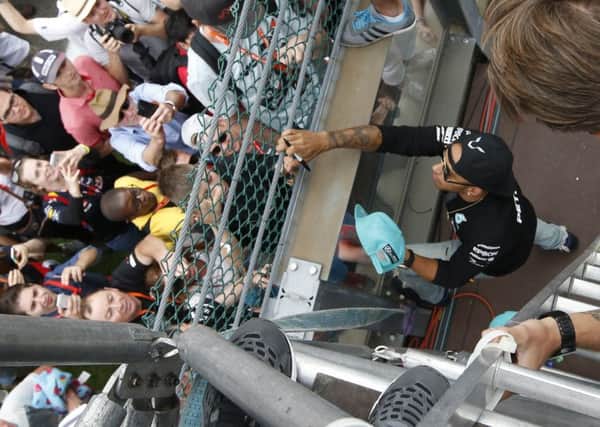 World championr Lewis Hamilton signs autographs for supporters after winning the Belgium Grand Prix, at the Spa-Francorchamps circuit, Belgium (Picture: Luca Bruno/AP).