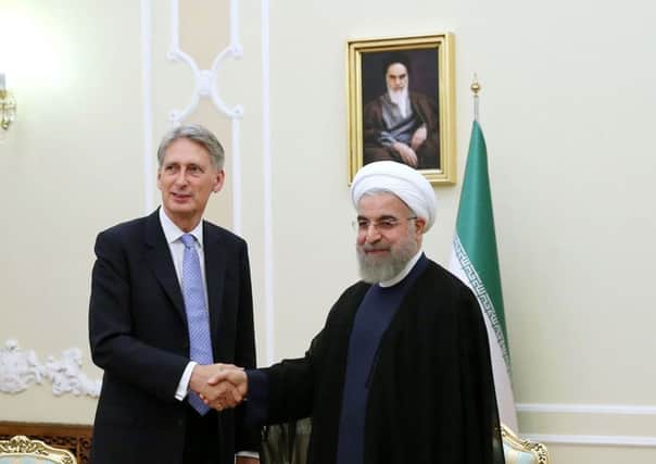 Iran's President Hassan Rouhani, right, welcomes British Foreign Secretary Philip Hammond at the start of their meeting in his office, in Tehran, Iran.