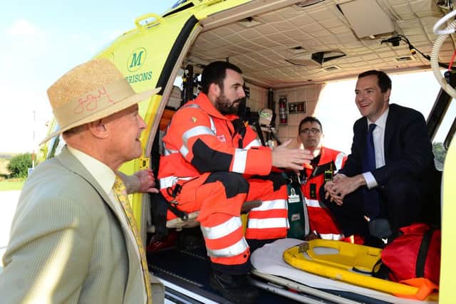 25 Aug 2015...Chancellor George Osborne chats with Geoffrey Boycott and paramedics during a visit to the Yorkshire Air Ambulance facility at Nostell Priory near Wakefield. Picture Scott Merrylees SM1009/26c