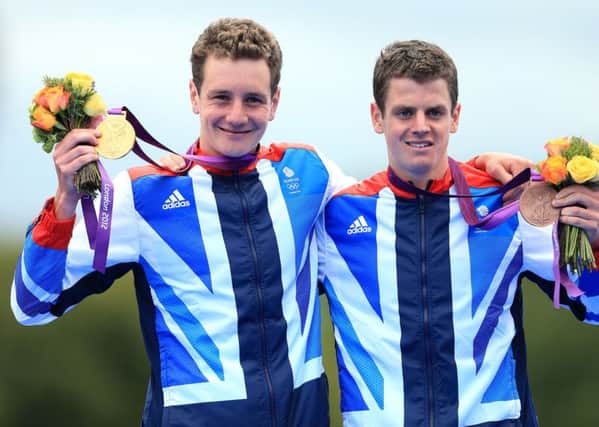 Alistair Brownlee celebrates with his gold medal and Jonathan Brownlee (right) celebrates with his bronze medal, after the Men's Triathlon at London 2012.