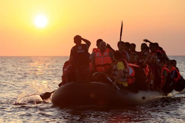 Migrants and refugees paddling a rubber dinghy close to the beach at Psalidi near Kos Town, Kos, Greece