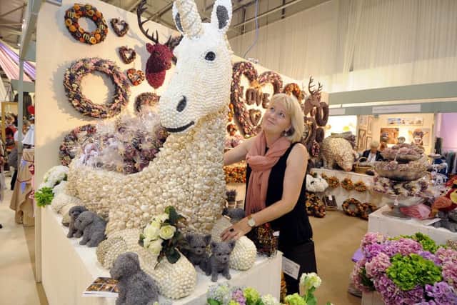 Exhibitor Camilla Laing admires a unicorn made from recycled shells