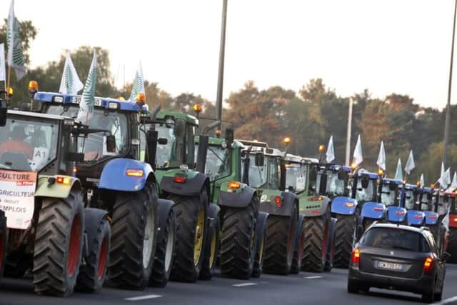 Farmers drive their tractors on the highway leading to Paris last Thursday in a protest over falling French food prices and high taxes. (AP Photo/Thibault Camus)