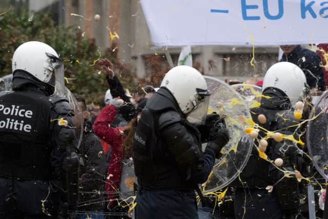 Riot police are hit with eggs during the farmers protest in the Belgian capital.  (AP Photo/Virginia Mayo)