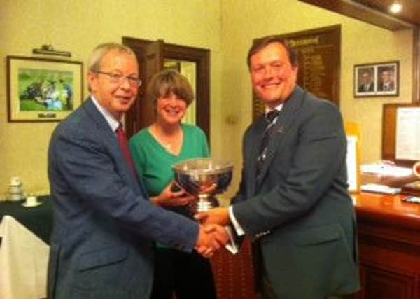 David and Claire Ineson receive the Fixby Masters trophy from Huddersfield captain Nick Ledgard.
