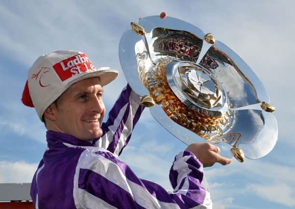 Jockey Colm O'Donoghue celebrates winning the Ladbrokes St Leger riding Bondi Beach after a stewards enquiry