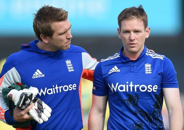 England's Eoin Morgan (right) leaves the pitch after being hit on the helmet by a delivery from Mitchell Starc. Picture: Martin Rickett/PA.