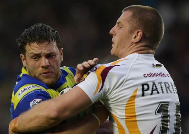 Simon Grix, left, seen being tackled by Huddersfield Giants' Larne Patrick, has joined Halifax after being released by Warrington Wolves (Picture: Dave Thompson/PA Wire).