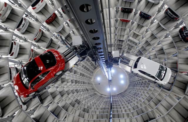 File photo shows a Volkswagen New Beetle being lifted inside a delivery tower after the company's annual press conference in Wolfsburg, Germany. Volkswagen CEO Martin Winterkorn promised full cooperation with the government following the company's admission it rigged nearly a half million cars to defeat U.S. smog tests.  (AP Photo/Michael Sohn, File)