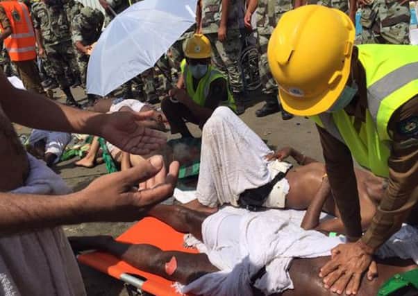 In this image posted on the official Twitter account of the directorate of the Saudi Civil Defense agency, a pilgrim is treated by a medic after a stampede that killed and injured pilgrims in the holy city of Mina