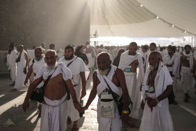 Muslim pilgrims walk after casting stones at a pillar symbolizing the stoning of Satan, in a ritual called "Jamarat," the last rite of the annual hajj, on the first day of Eid al-Adha, in Mina near the holy city of Mecca