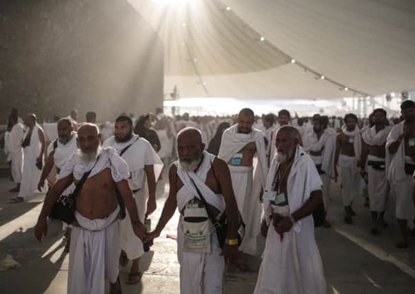 Muslim pilgrims walk after casting stones at a pillar symbolizing the stoning of Satan, in a ritual called "Jamarat," the last rite of the annual hajj, on the first day of Eid al-Adha, in Mina near the holy city of Mecca, Saudi Arabia