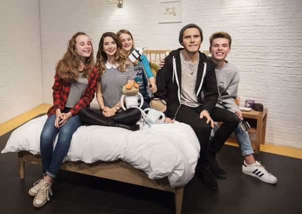 Fans pose for pictures with waxwork figures of vloggers Zoe Sugg and Alfie Deyes (also known as Zoella and PointlessBlog) sitting in an exact replica of the spare bedroom they often vlog from, in a new YouTube-themed exhibit at Madame Tussauds in London.