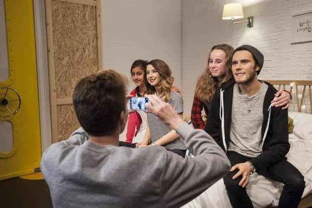 Fans pose for pictures with waxwork figures of vloggers Zoe Sugg and Alfie Deyes (also known as Zoella and PointlessBlog) sitting in an exact replica of the spare bedroom they often vlog from, in a new YouTube-themed exhibit at Madame Tussauds in London.
