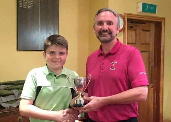 Doncaster GC junior organiser Simon Longworth presents the Junior Cup to the winner, his son Shane.