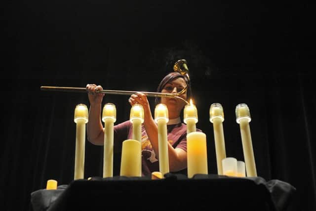 Jess Daum, pastor at Table of Grace, lights a candle during a Harrisburg Community Prayer Service at the Harrisburg High School(Joe Ahlquist/The Argus Leader via AP)