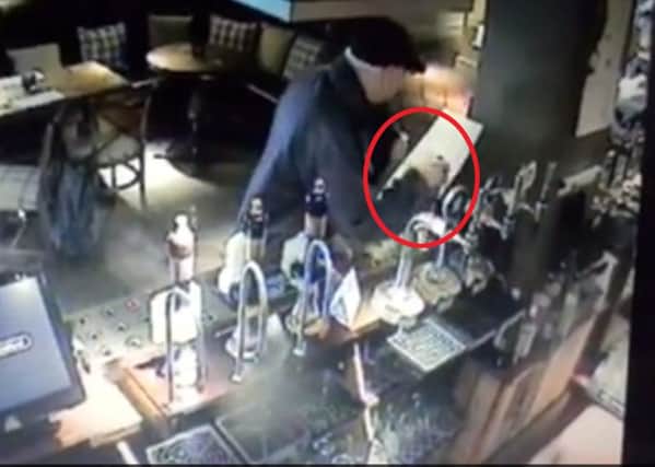 A man dubbed Britain's meanest thief was caught on CCTV walking calmly after swiping a charity box from the bar. PicturRoss Parry Agency