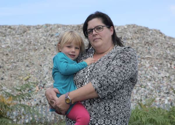 Sarah Webster and her three-year-old daughter, Eloise outside Brocklesby Building Products Limited where a ten thousand ton pile of rubbish resides in Great Heck, Yorkshire. October Picture: Ross Parry Agency