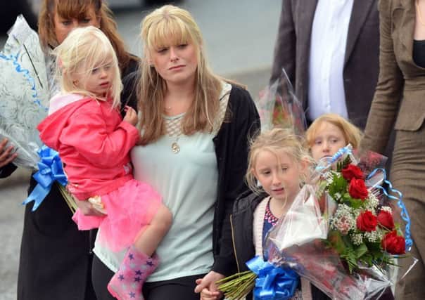 The family of Pc David Phillips, Jen (wife) and daughters Abigail and Sophie visit the scene in Wallasey where the Merseyside officer was mown down and killed by a stolen car early on Monday. PRESS ASSOCIATION Photo. Picture date: Wednesday October 7, 2015. See PA story POLICE Car. Photo credit should read: Billy Griffiths/PA Wire